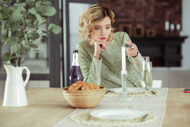 istock Heartbroken girlfriend sitting at table with alcohol and croissants alone 1136220833