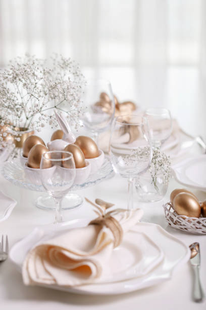 istock Happy Easter! Golden decor and table setting of the Easter table with white dishes of white color. 1136222422