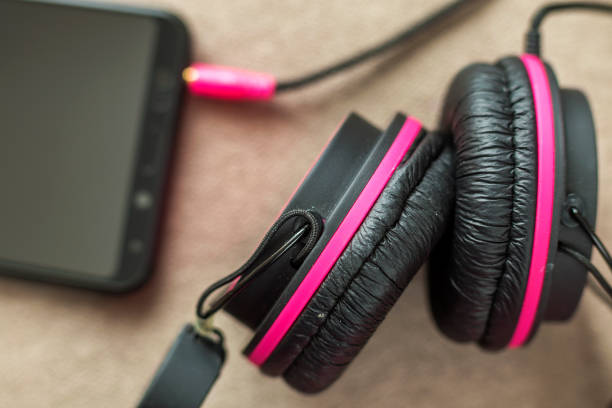 istock Headphone connected to cellphone isolated on light cloth flat copy space background. Modern technology, trendy entertainment, gadget design and accessories concept. 1136226348