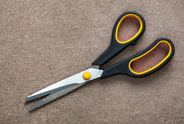 istock Close-up of sharp steel metal scissors isolated on light cloth copy space background. Household equipment, office or school tools. 1136226350