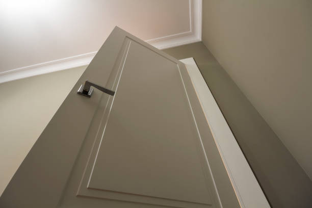istock Apartment after renovation interior. White door with metal handle, light walls and ceiling, angle view. 1136226377