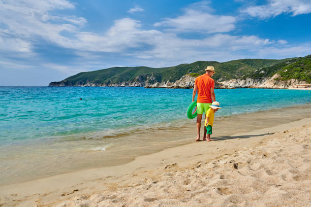 young father playing with his son with rock on beach, happy lifestyle family close up