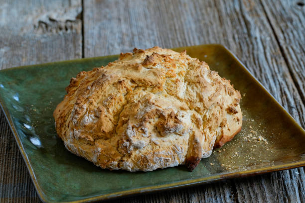 Freshly baked irish soda bread cutted into slices with big knife lying on the side. Healthy, homemade, delicious pastry.