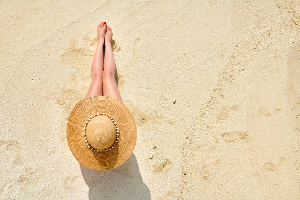 istock Woman sitting on beach view from above 1136232754