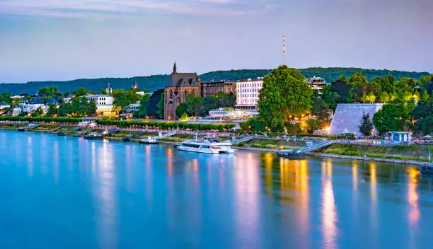 Skyline of Bonn, Germany. Beautiful night shot of great german city. Panorama with trees and historic architecture reflected in the water.
