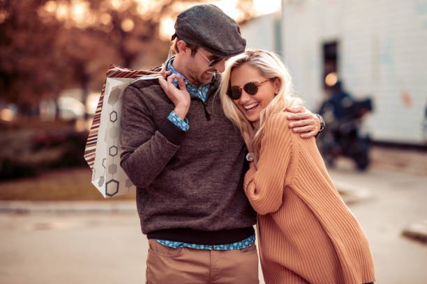 Shopping Happy loving couple carrying shopping bags and enjoying together. well dressed stock pictures, royalty-free photos & images