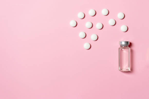 istock Bottle with antibiotics for injections and white tablets on pink background with copy space 1136238187