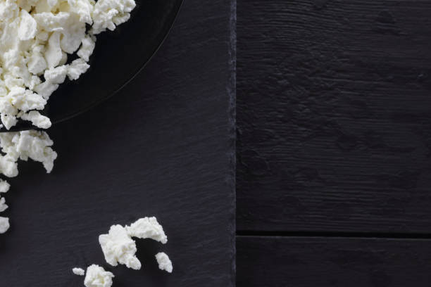 istock Cottage cheese on black slate board. Cheese on black plate. Soft cheese for diet on black boards. Healthy dairy product for breakfast. Concept 1136239880