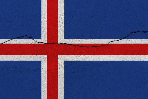 Iceland flag on concrete wall with crack. Patriotic grunge background. National flag of Iceland