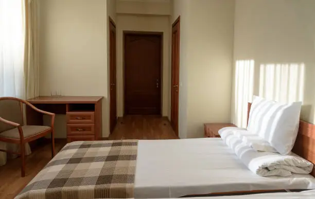 interior of comfortable budget hotel bedroom with bed