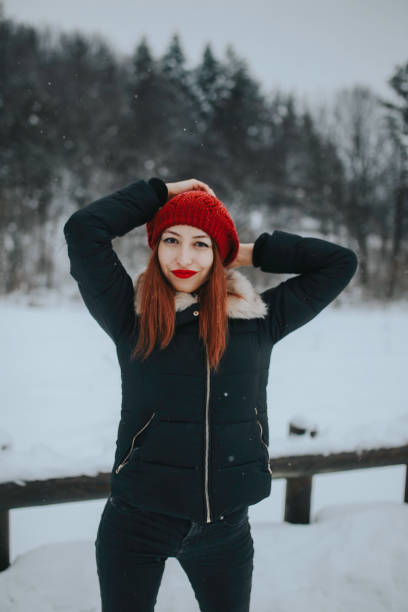 young woman with red cap on his head in snowy weather