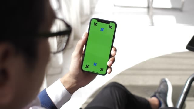 Man using phone with green screen hold in hands