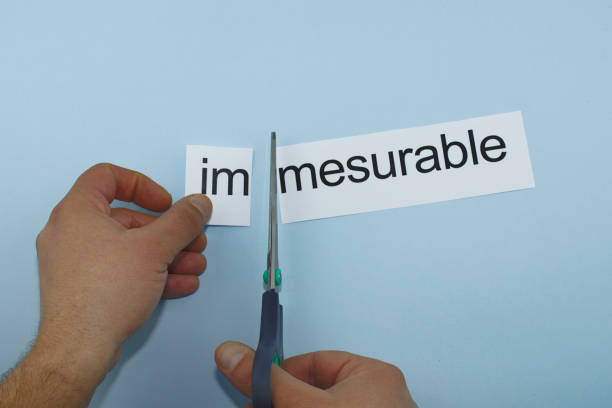 istock immesurable and mesurable.hand cutting paper with scissors 1136245195