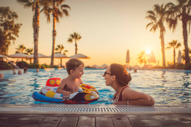 niño con madre en la piscina, resort de vacaciones - exploración fotos fotografías e imágenes de stock