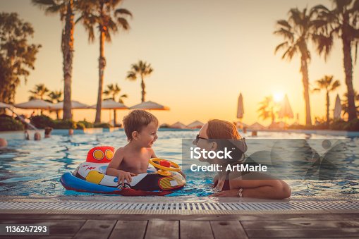 istock Child with mother in swimming pool, holiday resort 1136247293