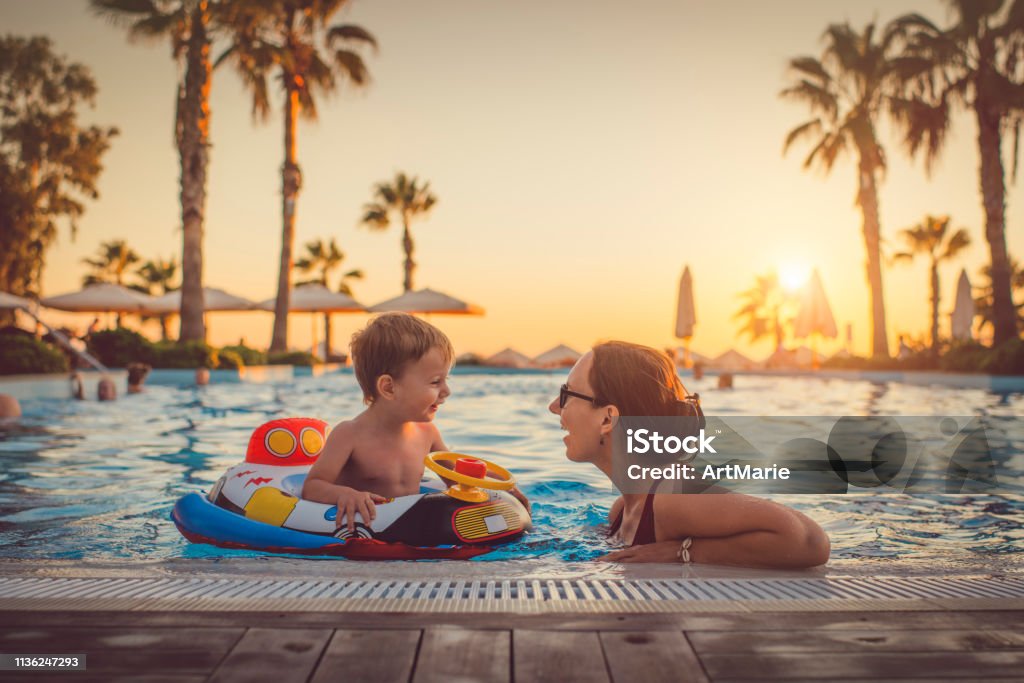 Child with mother in swimming pool, holiday resort Family having fun on summer vacations Family Stock Photo