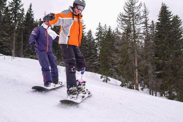 istock Amputee Snowboarder with Prosthetic Leg 1136249620