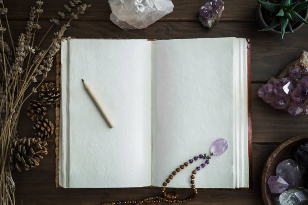 istock Open leatherbound notebook or journal surrounded by crystals plants and foliage 1136257836