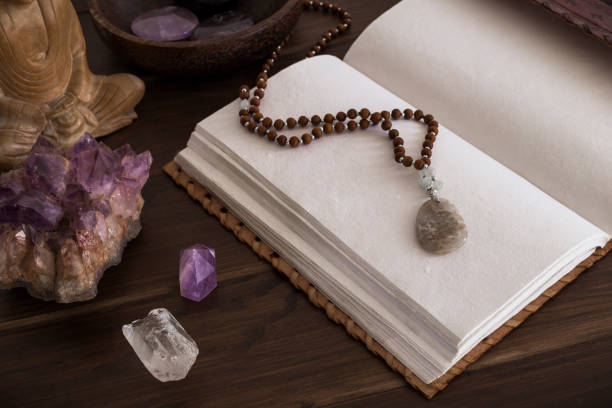 istock Open leatherbound journal or notebook surrounded by crystals on a wooden surface 1136257852