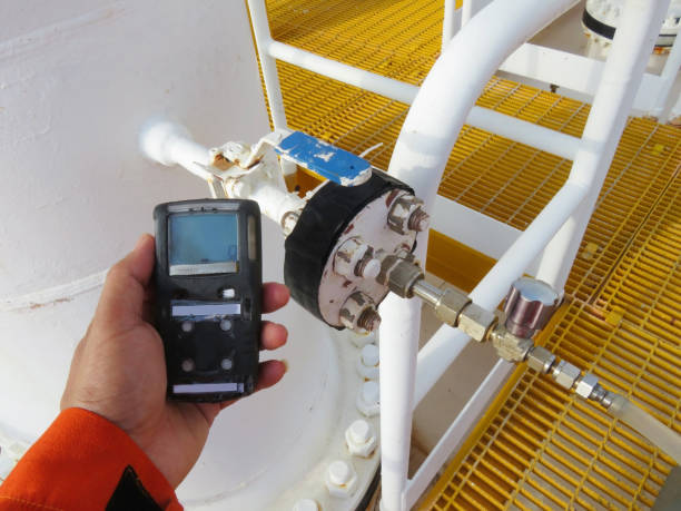 personal h2s detector de gás, verificar vazamento de gás. conceito da segurança do sistema de segurança na plataforma de processamento offshore do óleo e do gás, detector de gás da preensão da mão. - sulfide - fotografias e filmes do acervo