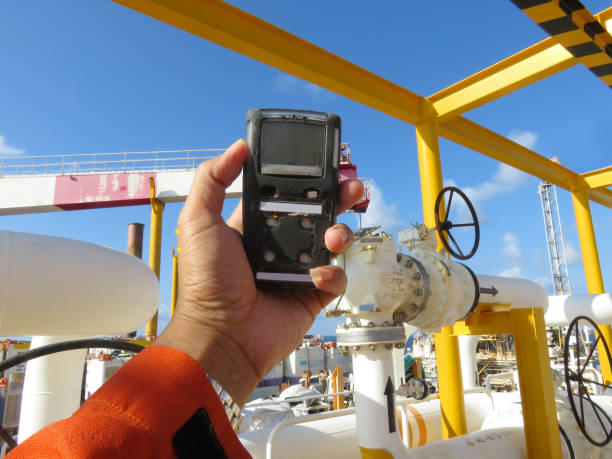 personal h2s gas detector,check gas leak. safety concept of safety and security system on offshore oil and gas processing platform, hand hold gas detector. - gas natural gas leaking sensor imagens e fotografias de stock