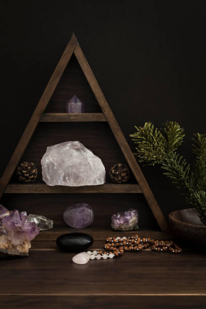 istock Triangular crystal shelf on a wooden surface with jewellery stones and foliage 1136259136
