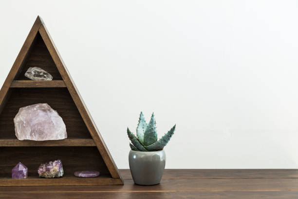 istock Triangular wooden crystal shelf on a wooden surface with potted succulent plant 1136259247