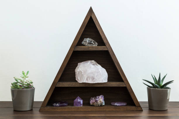 istock Triangular wooden crystal shelf with succulent plants either side on a wooden surface 1136259355
