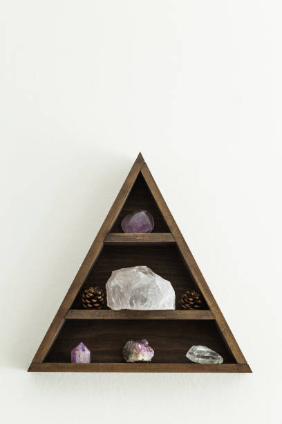 istock Wooden triangular crystal shelf with stones and pine cones hung on a wall 1136260108