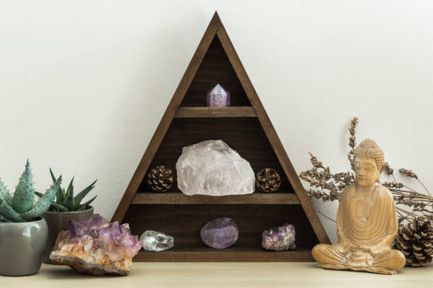 Triangular wooden crystal shelf with succulent plants foliage and wooden statue of Buddha Triangular wooden crystal shelf with succulent plants foliage and wooden statue of Buddha chakra recovery energy gem stock pictures, royalty-free photos & images