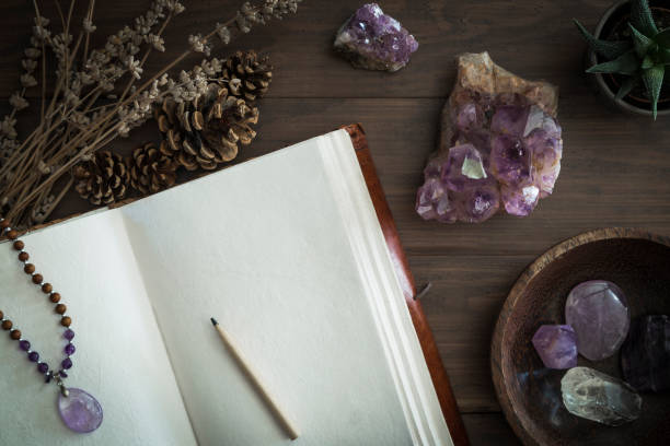 istock Open leatherbound journal or notebook surrounded by amethyst crystals dried lavender and succulent plant 1136260283