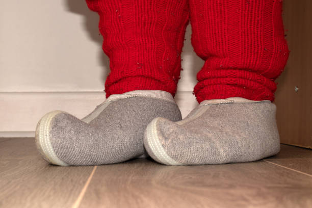 istock Red knitted socks and woolen slippers on the feet 1136260419