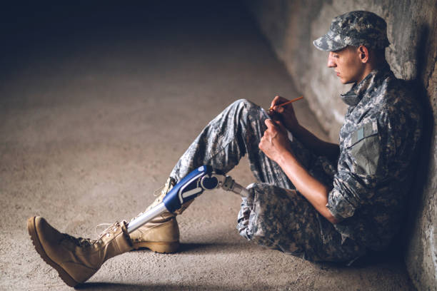 istock Soldier with prosthetic leg writing letter 1136260480