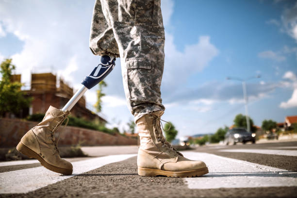 soldier with prosthetic leg crossing road - homecoming imagens e fotografias de stock