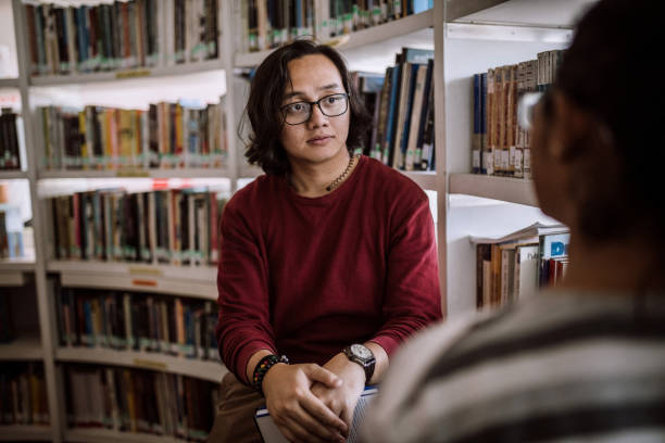 istock Indian woman and Malaysian man having friendly chat at library 1136261830