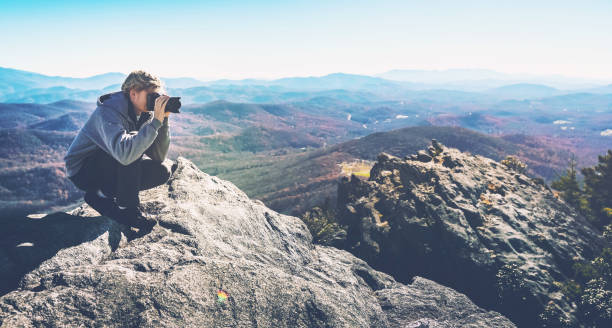 istock Man with a camera on top of a cliff 1136275094