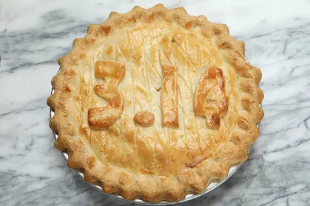 An overhead close up horizontal photograph of an apple pie with the numbers 3.14 which is the value of PI. It is intended to celebrate Pi Day on March the fourteenth which happens to be on 3.14.