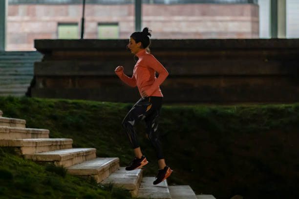istock Woman jogging in stadium hallway 1136276829
