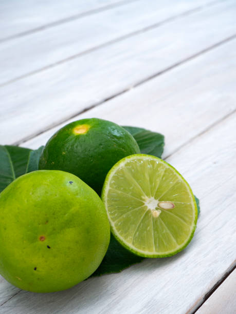 istock Lemons and limes with green leafs 1136279674