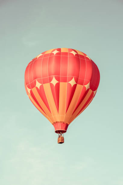 Orange hot air balloon in the sky. Retro styled image.