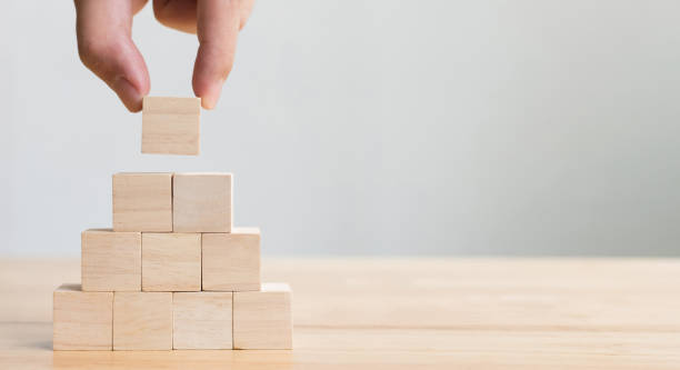 Hand arranging wood block stacking as step stair. Business concept for growth success process