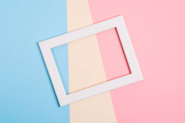 istock Colorful paper background with white wooden frame 1136285499