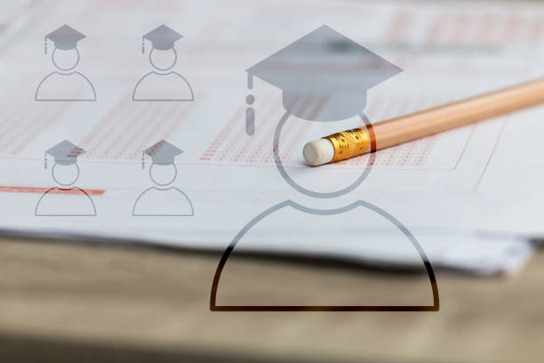 istock Pencil eraser and graduate study school icon on standardized test exam multiple carbon paper form answers bubbled at university classroom. Graduation diploma examination knowledge in school concept 1136287682
