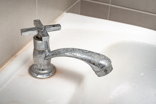 Dirty faucet with stain and limescale in bathroom