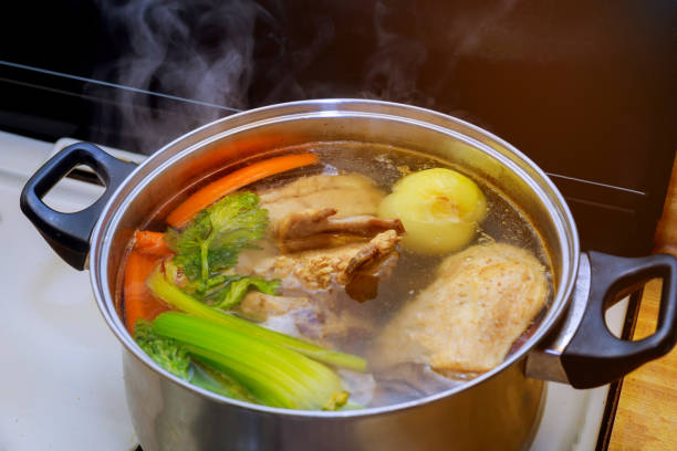 Chicken soup broth ingredients carrots chicken with vegetables Chicken soup broth ingredients carrots chicken with vegetables soup in a pot boiled stock pictures, royalty-free photos & images