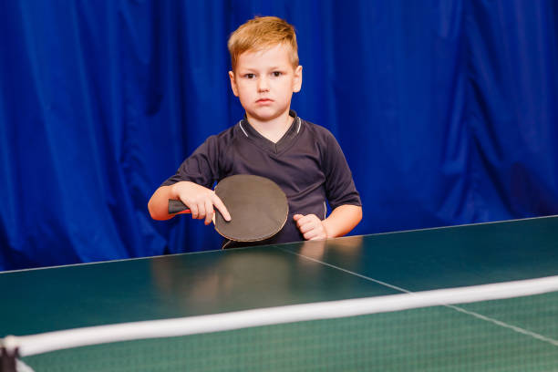 istock seven years boy holding a black racket for table tennis indoors 1136294262