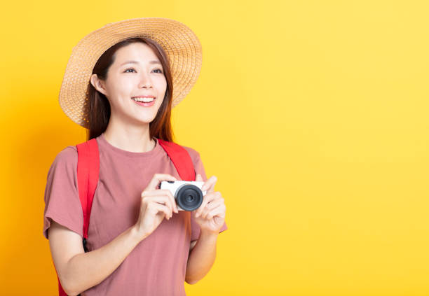 istock happy young woman in summer hat and holding camera 1136295066