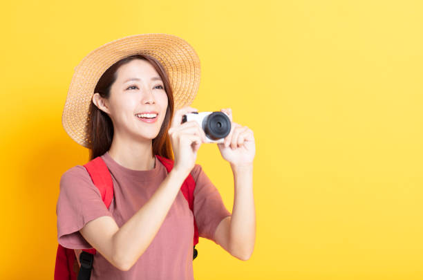 istock happy young woman in summer hat and holding camera 1136295215