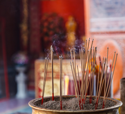Burning Incense in Chinese Buddhist Temple background, material offering of traditional Mahayana Buddhist devotional practices for accumulation of merit. Religion, Travel Asia, Culture, Symbol concept