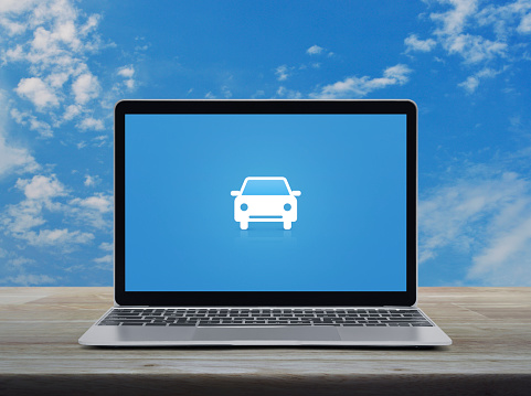 Taxi car flat icon with modern laptop computer on wooden table over blue sky with white clouds, Business service transportation online concept